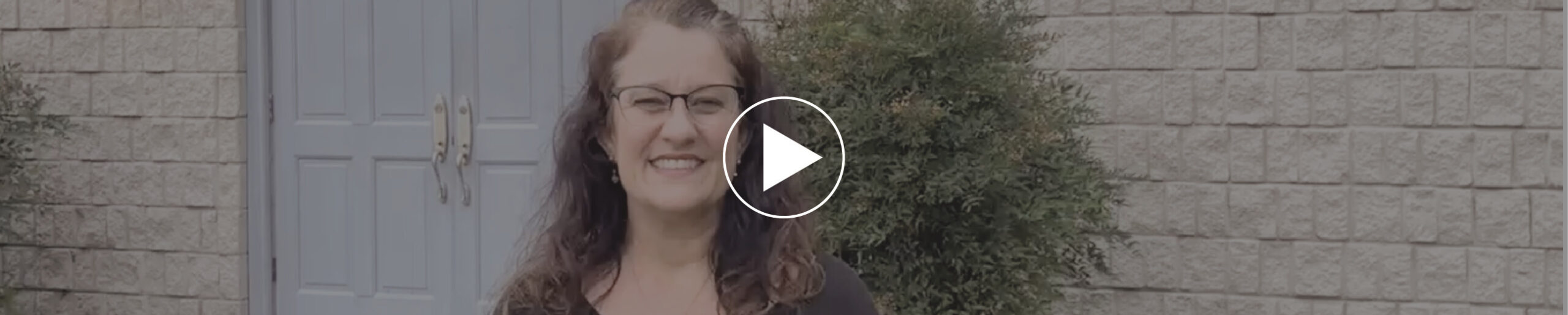 kelley ann standing in front of Faith Temple Church and a play video button
