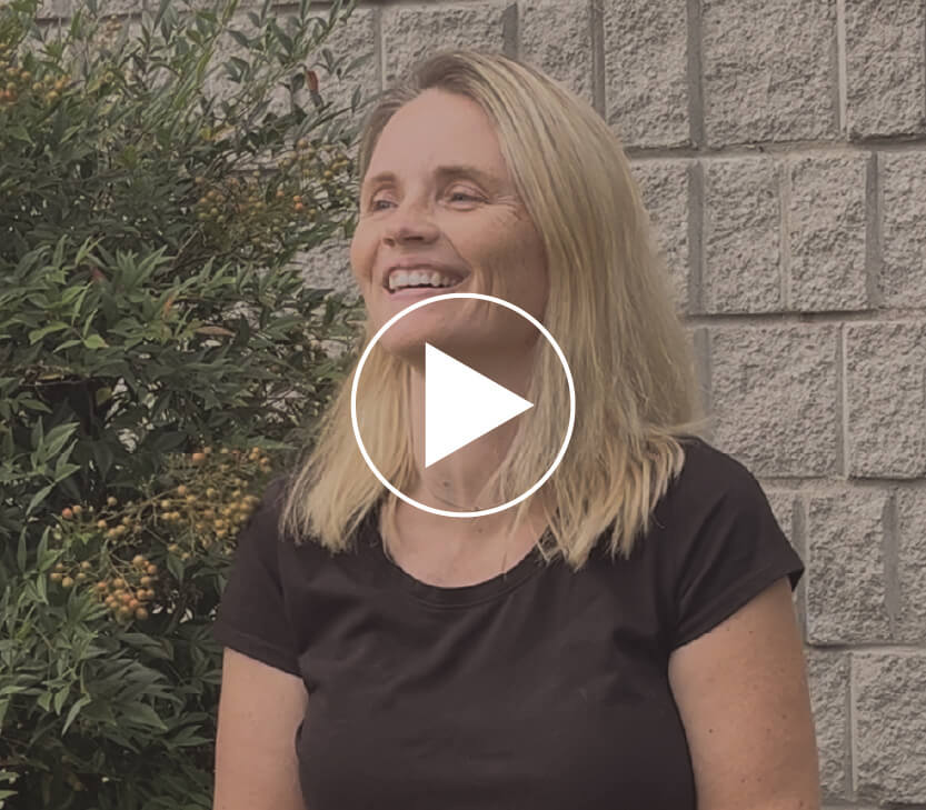 Johanna standing outside of Faith Temple Church and a play video button