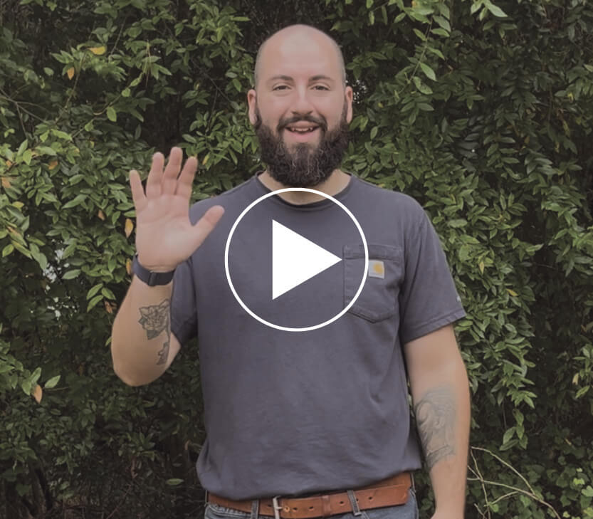 Ryan standing outside of Faith Temple Church and a play video button